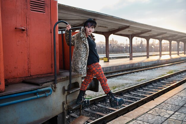 Pop punk aesthetic portrait of woman posing in locomotive