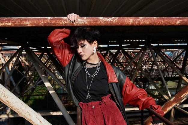 Free Photo pop punk aesthetic portrait of woman posing on metal structure