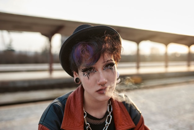 Free photo pop punk aesthetic portrait of woman posing in train station