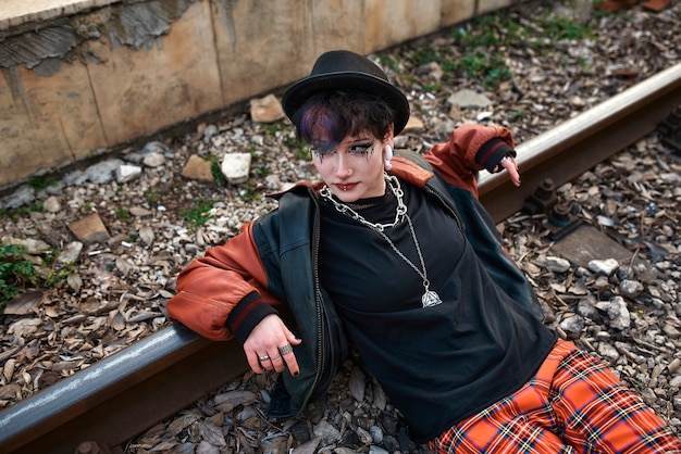 Pop punk aesthetic portrait of woman posing on train tracks