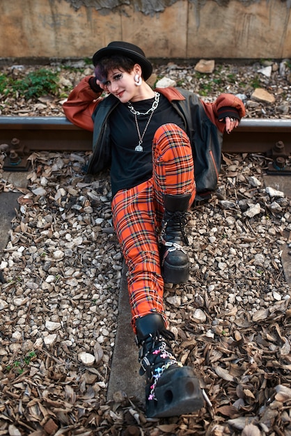 Pop punk aesthetic portrait of woman posing on train tracks