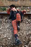 Free photo pop punk aesthetic portrait of woman posing on train tracks