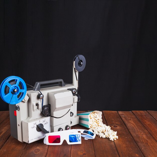 Popcorn and 3D glasses near movie projector