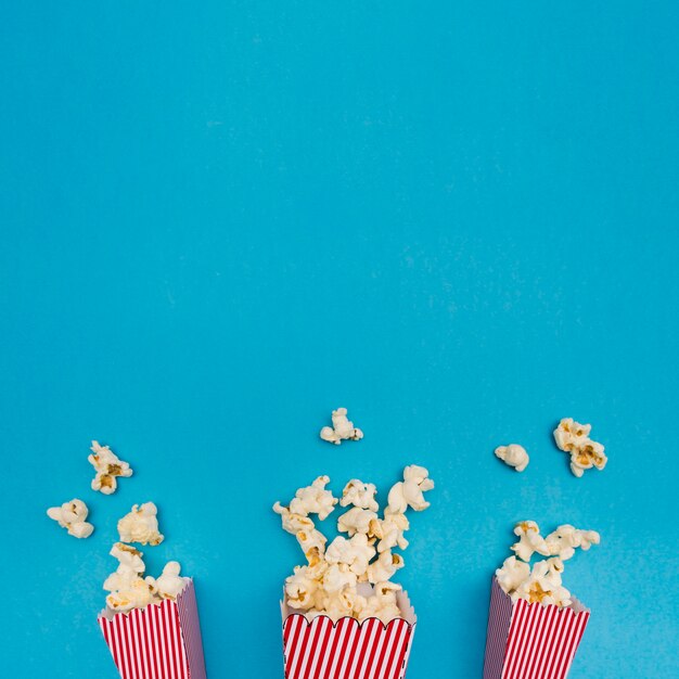 Popcorn composition on blue background with copy space