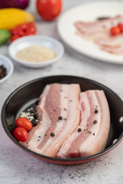 Pork belly in a pan with pepper seeds Tomatoes and spices