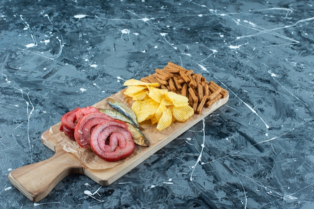 Free photo pork lard, fish, chips and breadcrumbs on a cutting board , on the blue table.