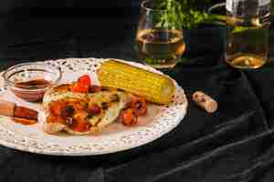 Free photo pork served with cherry tomatoes and corncob on plate