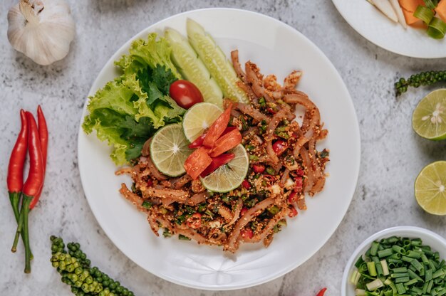 Pork Skin Larb with carrot, cucumber, lime, spring onion, chili, freshly ground pepper, and lettuce.