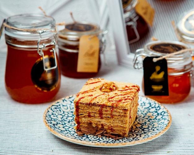 Free photo portioned square honey cake garnished with syrup and walnut