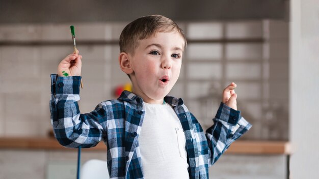 Portrait of adorable little child holding paint brush