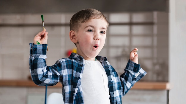 Portrait of adorable little child holding paint brush