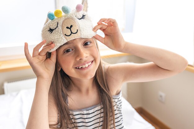 Portrait of adorable little girl walked up in her bed in the sunny morning