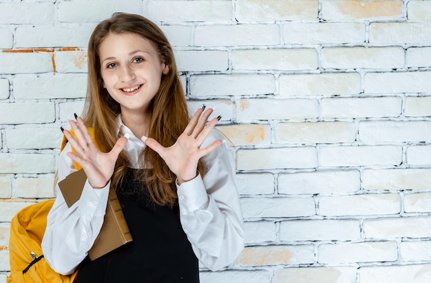 Free photo portrait of adorable student smiling and showing her hands to the camera high quality photo