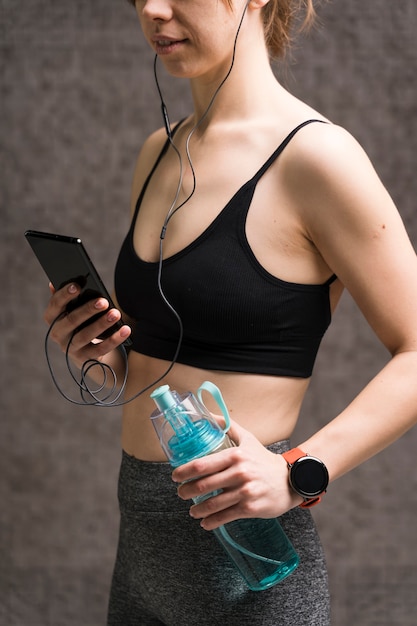 Free photo portrait of adult woman in sportswear holding phone