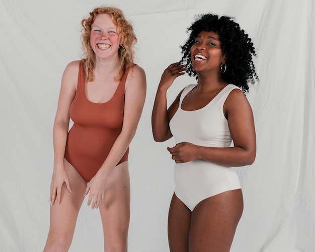 Free Photo portrait of an african and blonde young women looking at camera