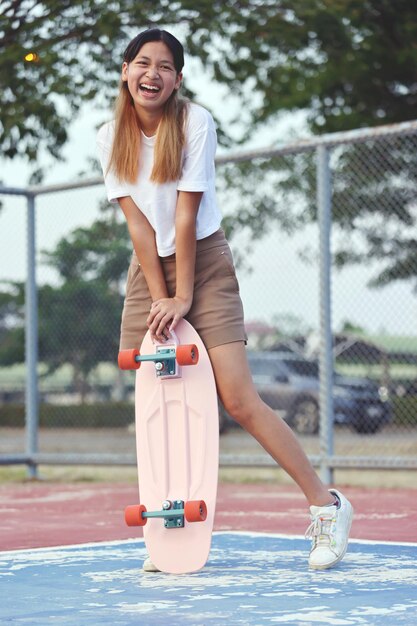 Portrait Asian Girl Holding Surf Skate Outdoors On Summer Day Teenager Lifestyle