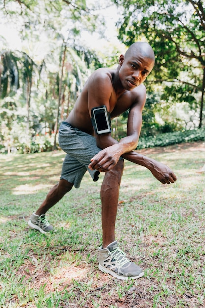 Portrait of a athlete young man at the park doing stretching exercises