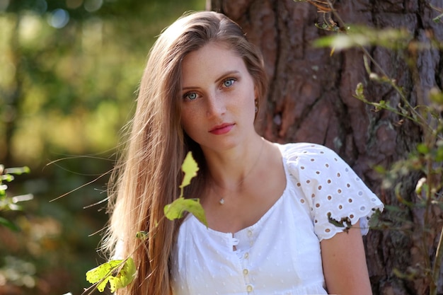 Free photo portrait of attractive frackled woman in autumn forest.