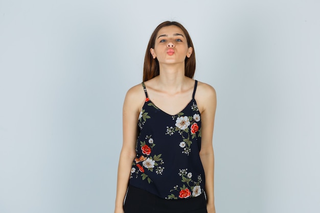 Free photo portrait of attractive lady pouting lips in blouse and looking confident front view