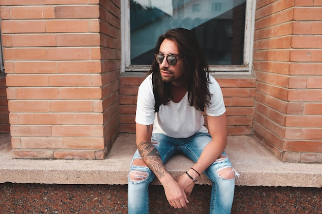 Free photo portrait attractive man near window on urban scene