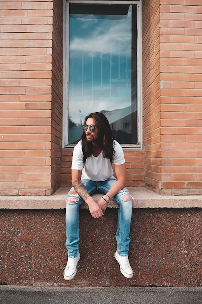 Portrait attractive man near window on urban scene