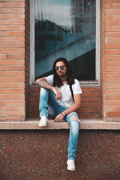 Portrait attractive man near window on urban scene