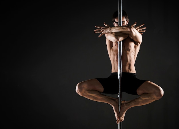 Free photo portrait of attractive man performing a pole dance