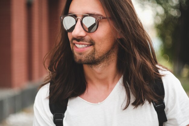 Portrait attractive man with sunglasses on urban scene smiling