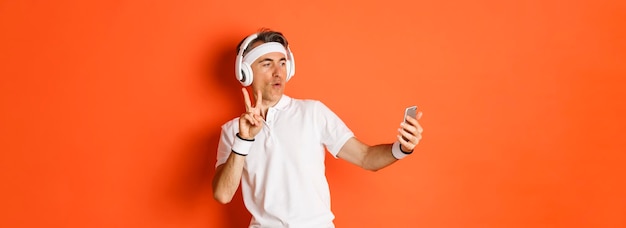 Free Photo portrait of attractive middleaged male athlete taking selfie during workout training showing peace s