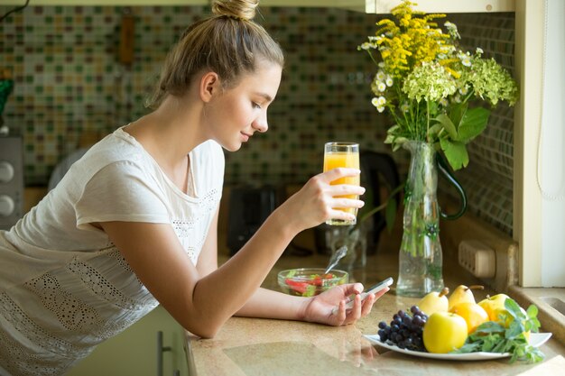 Free photo portrait of an attractive woman with juice and phone