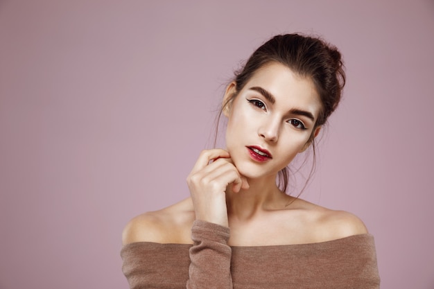 Free photo portrait of attractive woman with makeup posing on pink