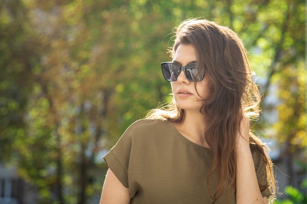 Portrait of an attractive young woman on a blurred background on a sunny day