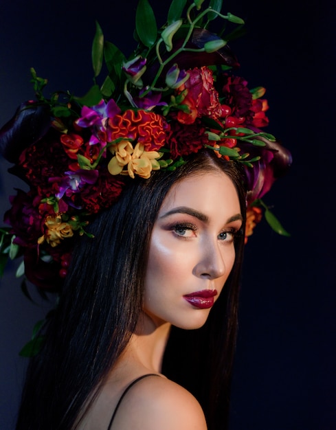 Free photo portrait of attractive young woman with bright make-up dressed in big colorful floral wreath