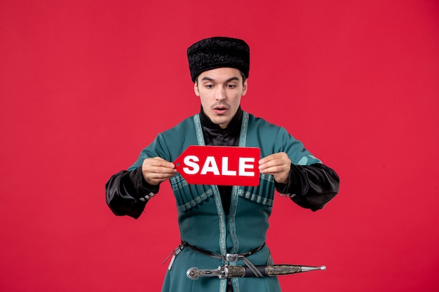 Free photo portrait of azeri man in traditional costume holding sale