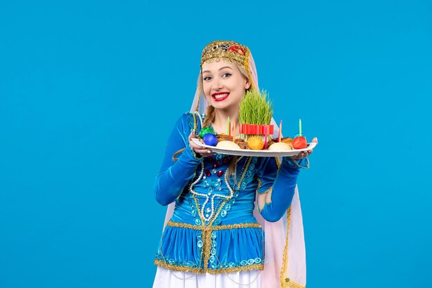 Portrait of azeri woman in traditional dress with novruz xonca studio shot blue background concept ethnic dancer