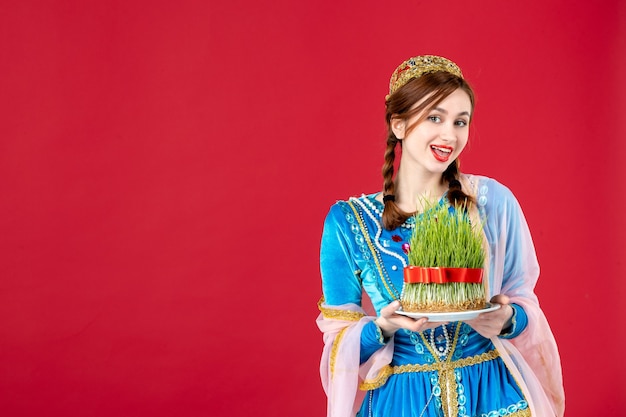 Free photo portrait of azeri woman in traditional dress with semeni on red