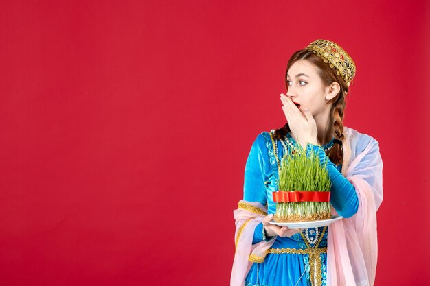 Portrait of azeri woman in traditional dress with semeni on red