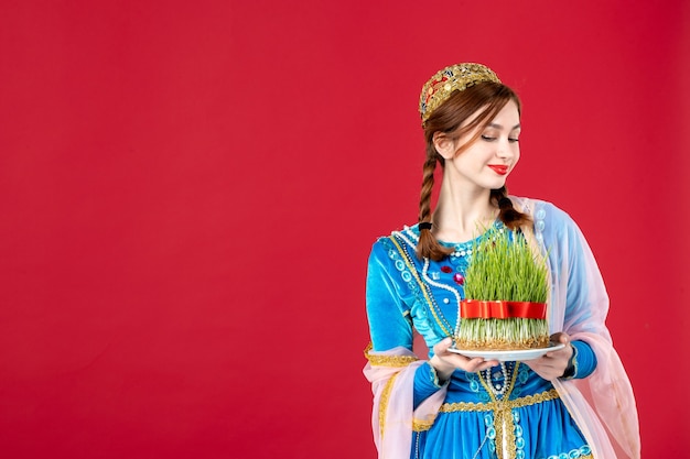 Portrait of azeri woman in traditional dress with semeni on red