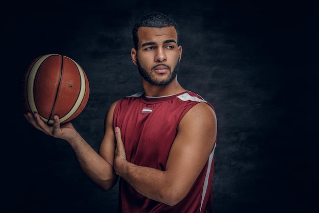 Portrait of a bearded black man holds a basket ball.