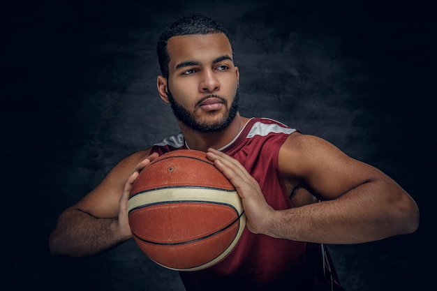 Portrait of a bearded black man holds a basket ball.