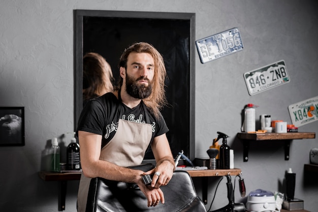 Free photo portrait of a bearded hairstylist looking at camera