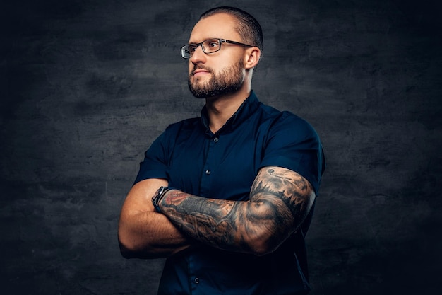 Free photo portrait of bearded male in sunglasses with tattoo on his arm.