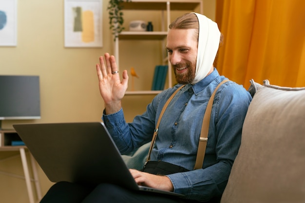 Free photo portrait of bearded man with ear bandage working on laptop