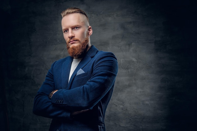 Free Photo portrait of bearded redhead hipster male dressed in a blue jacket over grey background.