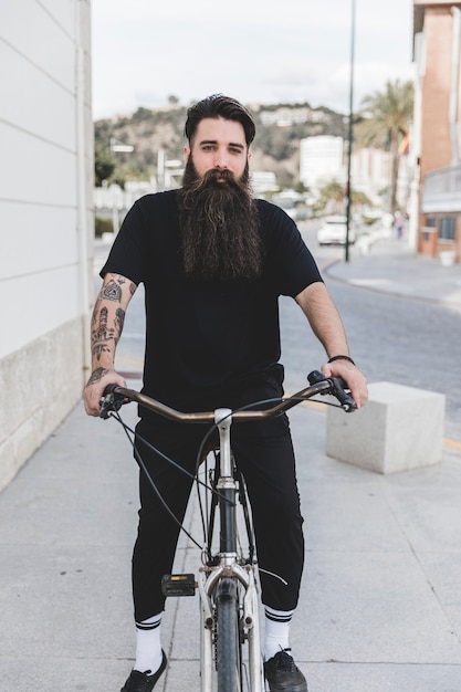 Portrait of a bearded young man sitting on bicycle