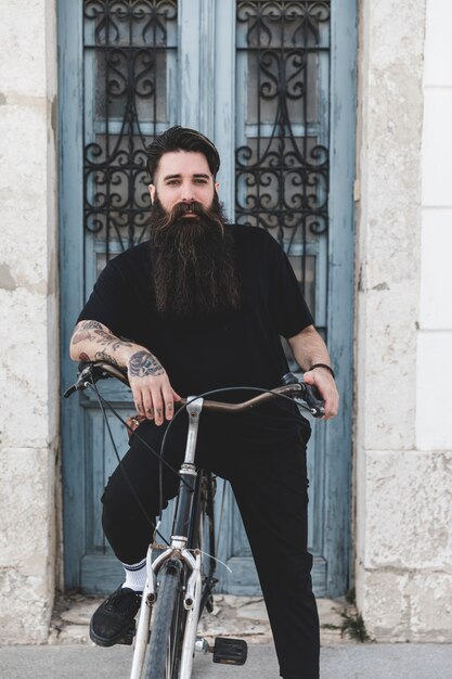 Portrait of a bearded young man with his bicycle