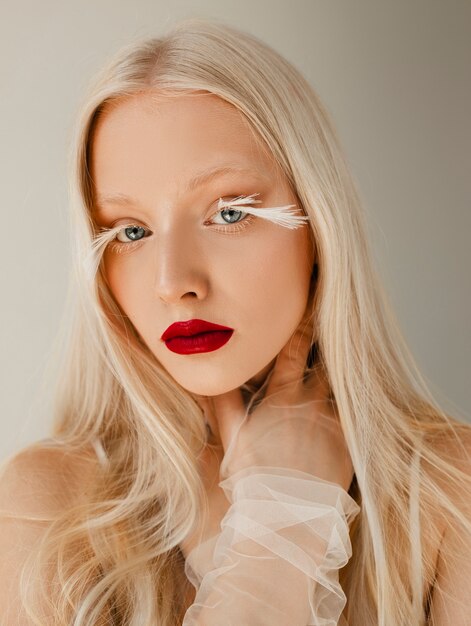 Free Photo portrait of beautiful albino woman with feathers as eyelashes