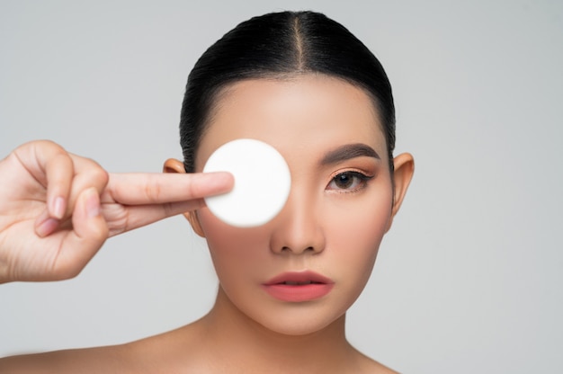 Portrait of Beautiful Asian woman holding foundation or cushion sponge puff