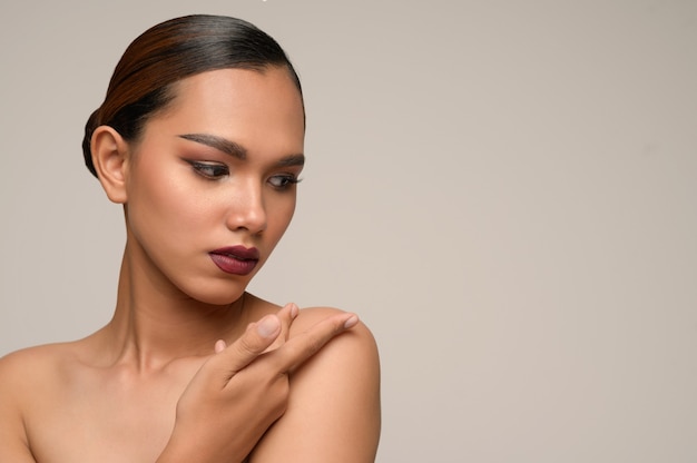 Free photo portrait of beautiful asian woman touches on her shoulder