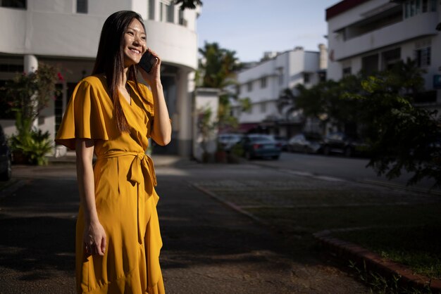 Portrait of beautiful asian woman using smartphone outdoors in the city